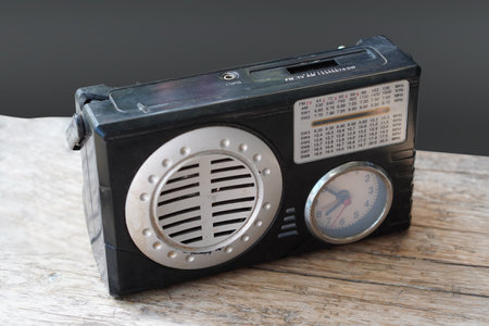 top view old and dirty black radio and clock on wooden floor, grey background, technology, object,...