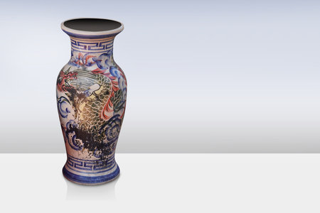 antique and old ceramic vase on white floor, gradient blue and white background, object background, decor, vintage, retro, fashion, copy spaceの写真素材