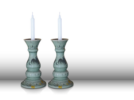 two white candles In a green ceramic candle holder on a white background, on gradient wall...