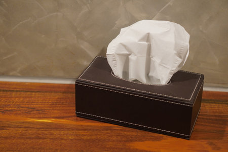 top view Tissue paper in a rectangular box, brown leather, placed on a wooden shelf, tiled wall...