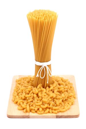 Spaghetti and macaroni on wooden boardの写真素材