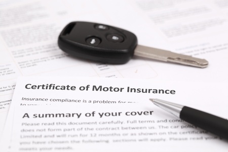 Certificate of motor insurance with car key and penの写真素材