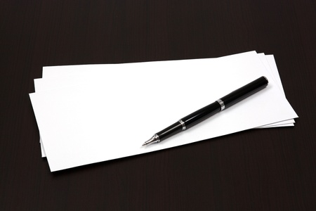 envelopes on a table with penの写真素材