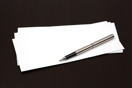 envelopes on a table with penの写真素材
