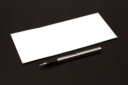 envelope on a table with penの写真素材