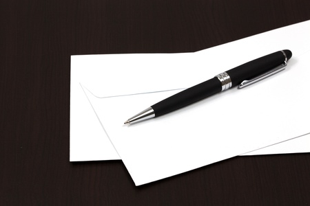 envelopes on a table with penの写真素材