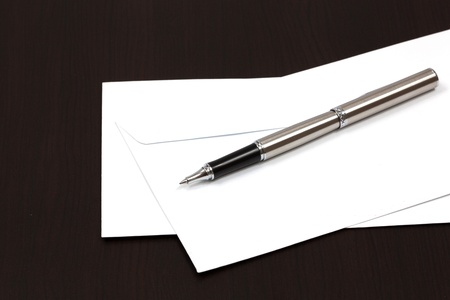envelopes on a table with penの写真素材