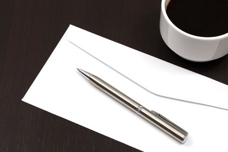 envelope on a table with pen and coffeeの写真素材