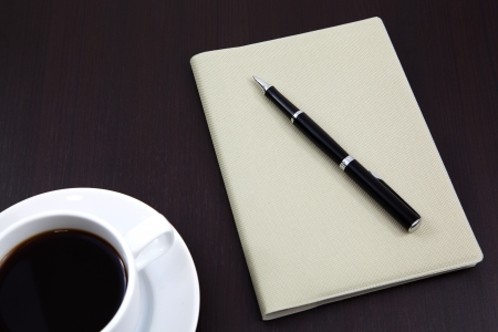 notebook with coffee cup on tableの写真素材