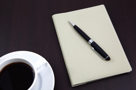 notebook with coffee cup on tableの写真素材