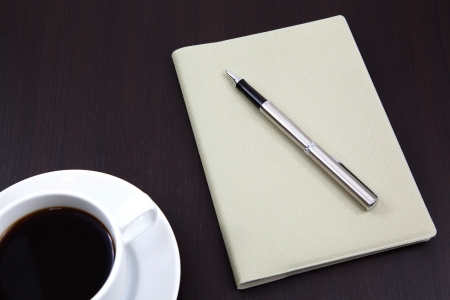 notebook with coffee cup on tableの写真素材