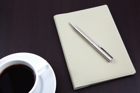 notebook with coffee cup on tableの写真素材