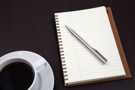 notebook with coffee cup on tableの写真素材