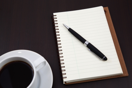 notebook with coffee cup on tableの写真素材