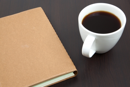 Cup of coffee on a wooden table with bookの写真素材