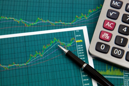 A pen and calculator on the Stock chart and financial reportの写真素材