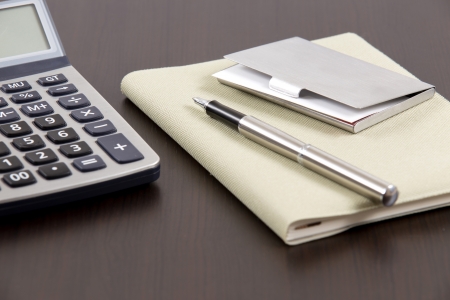 notebook and business card with calculator on tableの写真素材