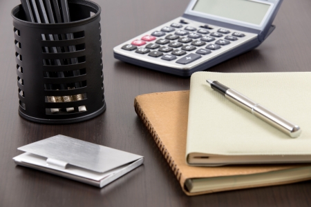 notebook and business card with calculator on tableの写真素材
