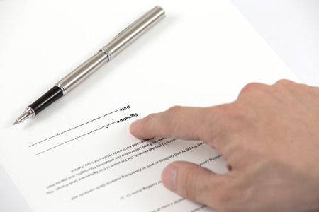 Signing a contract - hand with pen closeupの写真素材
