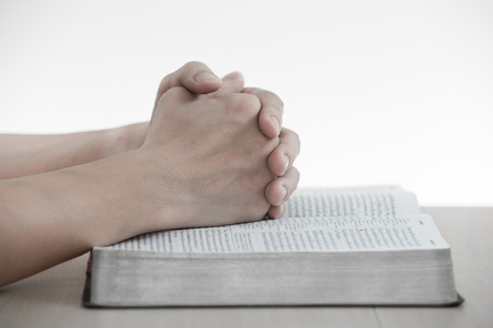 hands praying with bible on tableの写真素材