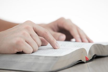 Close photo of man thumbing through the Bibleの写真素材