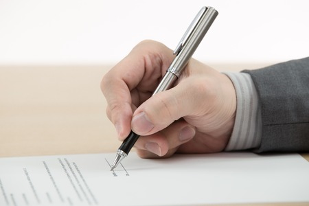 Business man signing finance contract on tableの写真素材