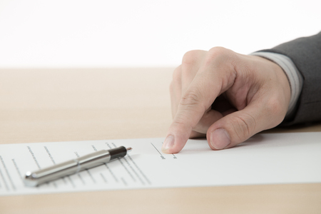 Business man signing finance contract on tableの写真素材