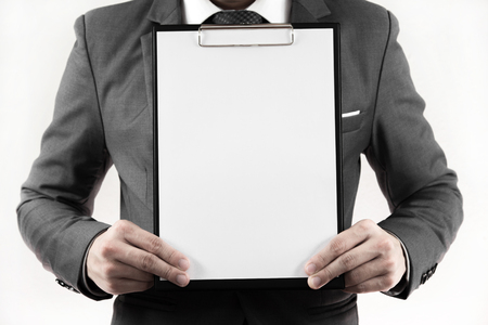 Business man in suit holding a blank clipboard. isolated on whiteの写真素材