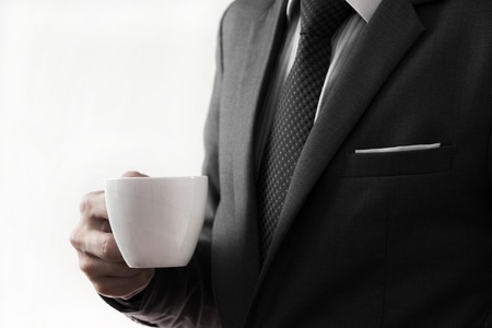 Business man offering cup of coffee. isolated on whiteの写真素材
