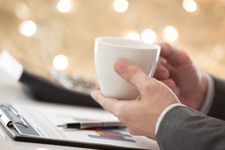 graphs and charts analyzed by businessman with coffeeの写真素材