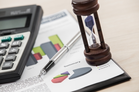 Financial graphs and charts with hourglass and calculatorの写真素材