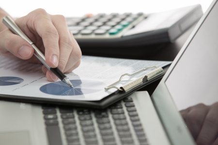 Businessman analyzing investment charts with laptopの写真素材