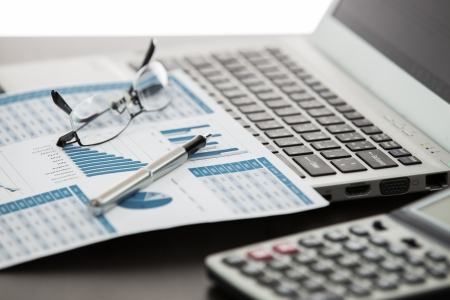 Businessman analyzing investment charts with laptopの写真素材