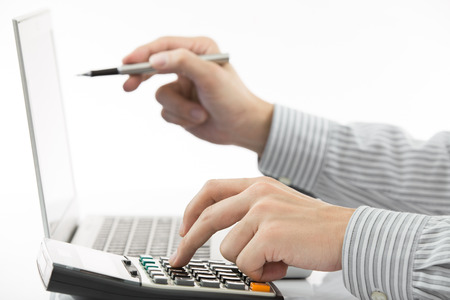 Businessman analyzing investment charts with laptopの写真素材