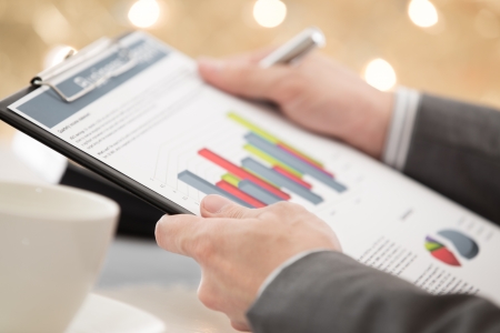 graphs and charts analyzed by businessman with coffeeの写真素材