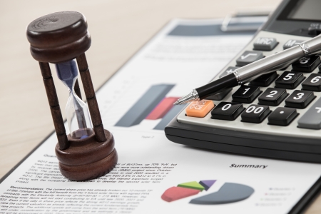 Financial graphs and charts with hourglass and calculatorの写真素材
