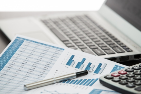 Businessman analyzing investment charts with laptopの写真素材