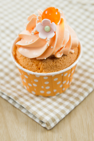 Tasty cupcake with butter cream on lights backgroundの写真素材