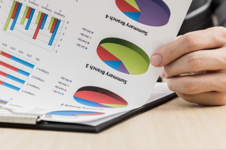 Businessman's hand showing financial report on tableの写真素材