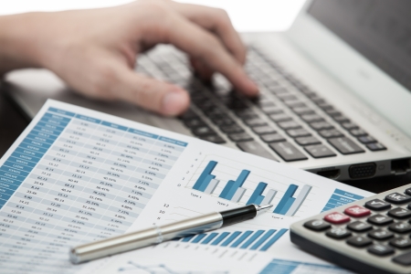 Businessman analyzing investment charts with laptopの写真素材