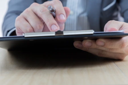 Businessman's hand showing financial report on tableの写真素材