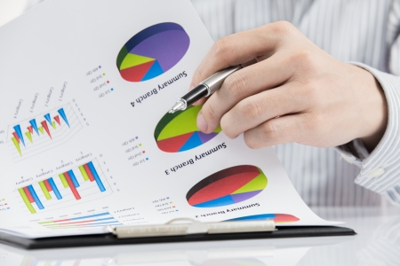 man hand with pen and business report on tableの写真素材