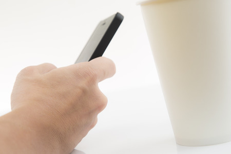 Close-up Of Businessman Using Cell Phone with coffee cupの写真素材