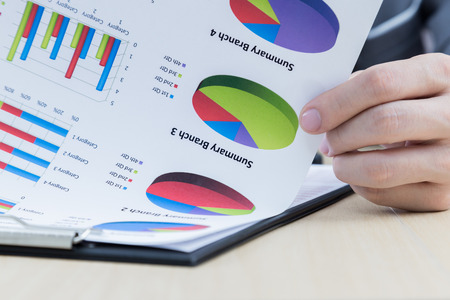 Businessman's hand showing financial report on tableの写真素材