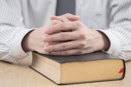 hands praying with bible on tableの写真素材