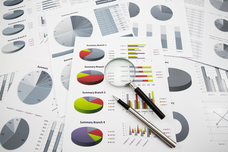 Business graph analysis reports with magnifying glass and penの写真素材