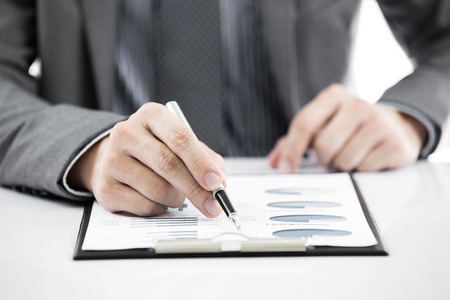 business report and man hand with penの写真素材