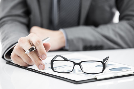 business report and man hand with pen. Accountingの写真素材