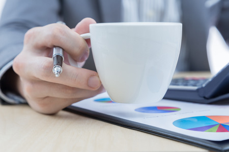 Businessman's hand showing financial report on tableの写真素材