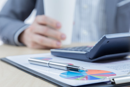Businessman's hand showing financial report on tableの写真素材